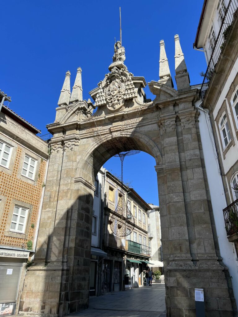 Arco da Porta Nova view from the street looking up with blue skies behind.