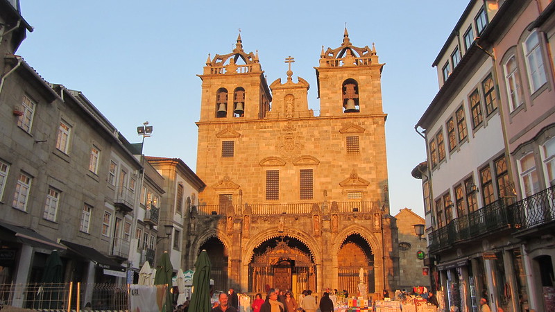 Braga Cathedral with a busy afternoon of foot traffic. Church is basking in the evening sunlight.