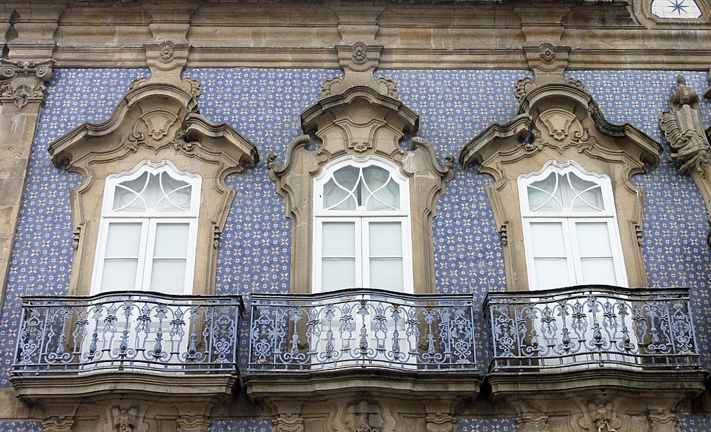 Ornate white exterior windows surrounded by blue tile and historic design. 